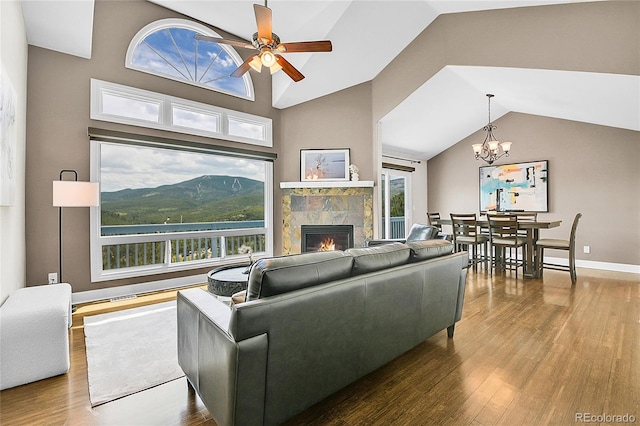 33633 Elk Run, Evergreen, CO 80439 - living area featuring wood finished floors, vaulted ceiling, a fireplace, ceiling fan, and a chandelier