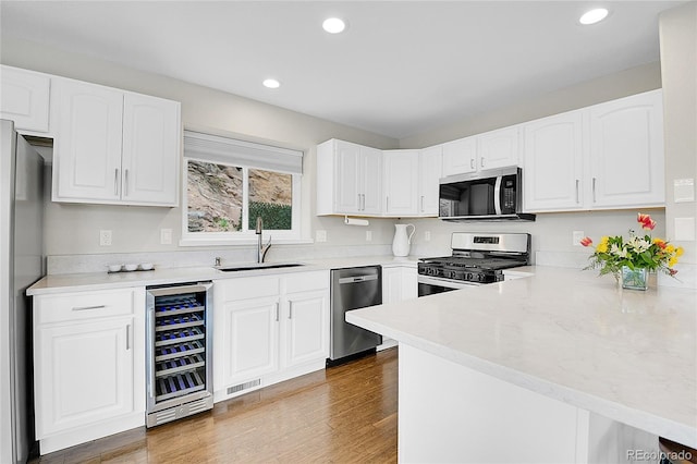 33633 Elk Run, Evergreen, CO 80439 - kitchen with appliances with stainless steel finishes, wine cooler, a sink, recessed lighting, and white cabinetry