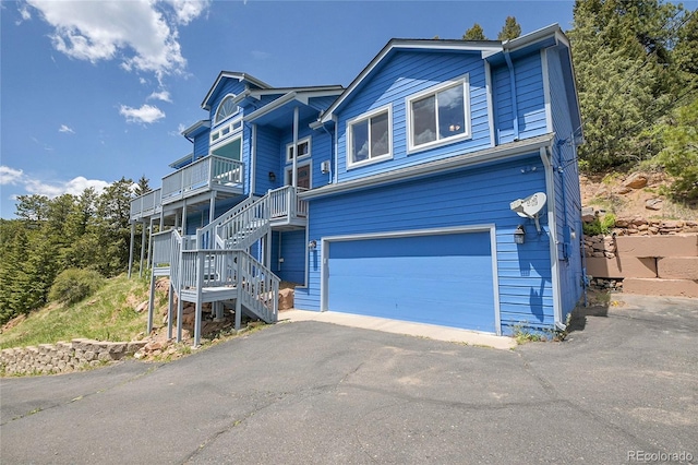 33633 Elk Run, Evergreen, CO 80439 - view of front facade with a garage, stairway, and asphalt driveway