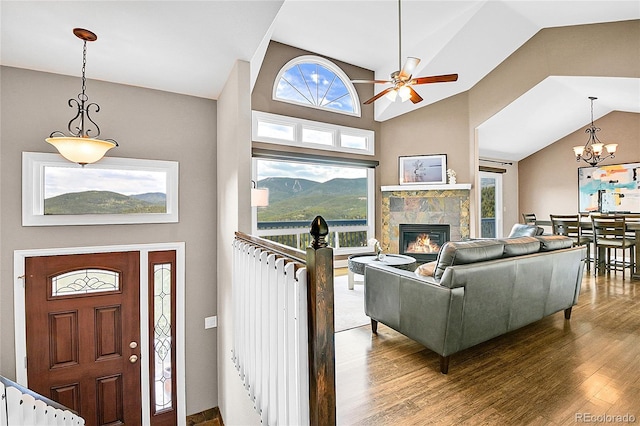 33633 Elk Run, Evergreen, CO 80439 - living room with wood finished floors, ceiling fan, a tiled fireplace, plenty of natural light, and vaulted ceiling