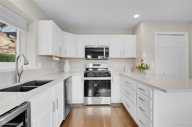 33633 Elk Run, Evergreen, CO 80439 - kitchen with appliances with stainless steel finishes, wine cooler, a sink, a peninsula, and recessed lighting