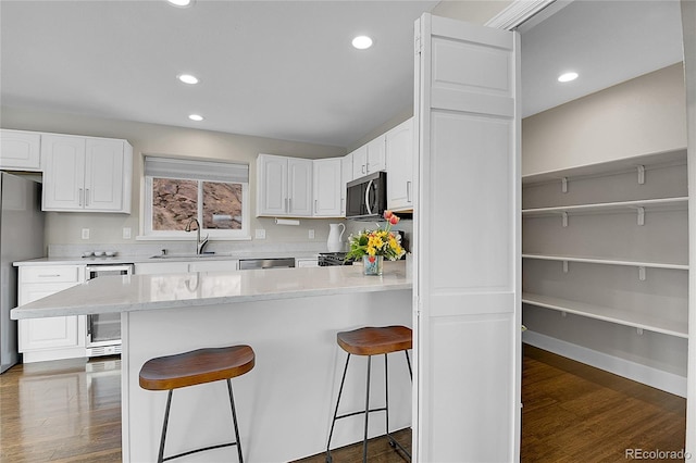 33633 Elk Run, Evergreen, CO 80439 - kitchen with a sink, white cabinetry, a kitchen breakfast bar, a peninsula, and appliances with stainless steel finishes
