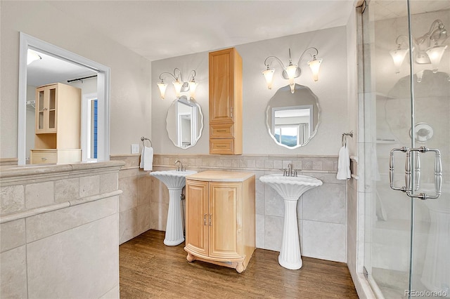 33633 Elk Run, Evergreen, CO 80439 - full bathroom with tile walls, a wainscoted wall, a stall shower, and wood finished floors