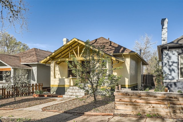 2421 Hooker St, Denver, CO 80211 - view of front facade with brick siding, a shingled roof, a chimney, and a porch