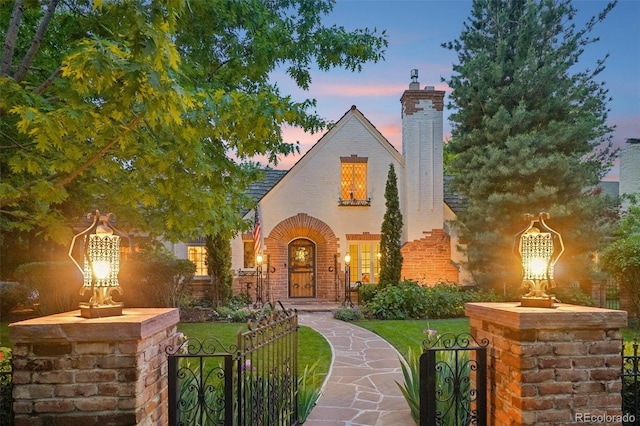 5530 E 6th Avenue Parkway, Denver, CO 80220 - tudor house featuring a gate, a chimney, and brick siding