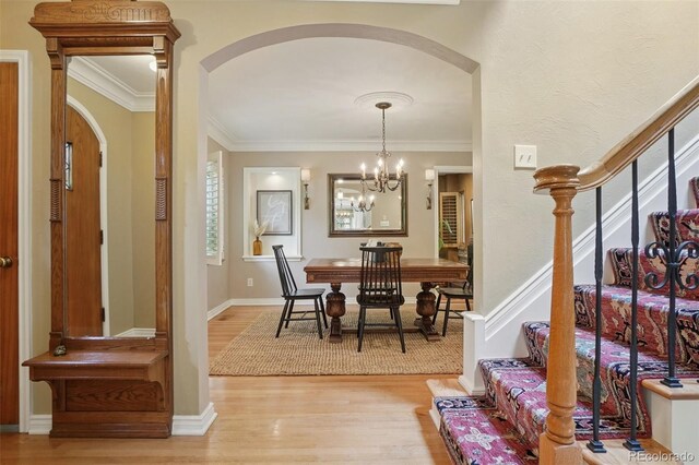 5530 E 6th Avenue Parkway, Denver, CO 80220 - dining room featuring arched walkways, wood finished floors, a chandelier, stairway, and crown molding