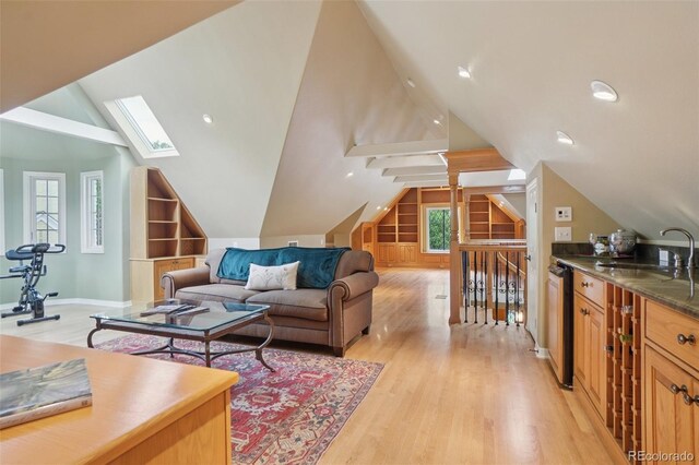 5530 E 6th Avenue Parkway, Denver, CO 80220 - living area featuring lofted ceiling, light wood-style floors, a skylight, built in features, and baseboards