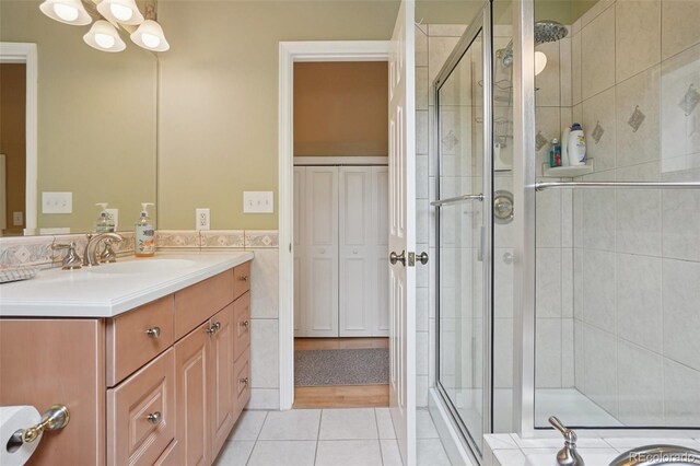 5530 E 6th Avenue Parkway, Denver, CO 80220 - full bath featuring a shower stall, vanity, tile patterned floors, tile walls, and a chandelier
