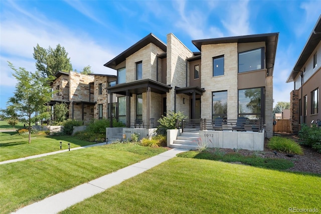 contemporary home with stone siding and a front lawn