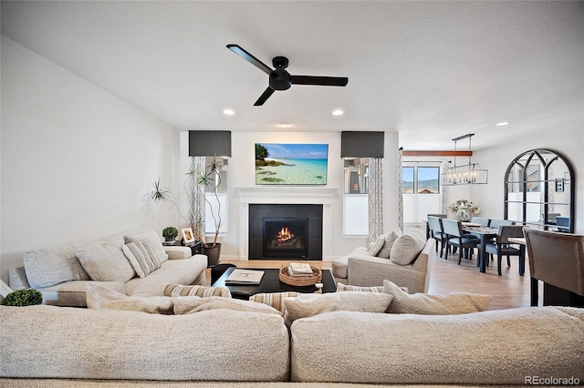 1485 Captiva Beach Ln, Monument, CO 80132 - living room featuring recessed lighting, a tiled fireplace, ceiling fan, a chandelier, and wood finished floors