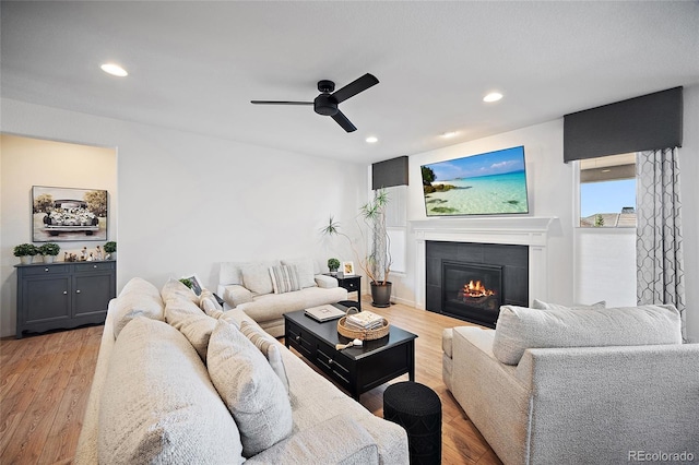 1485 Captiva Beach Ln, Monument, CO 80132 - living area with a tiled fireplace, a ceiling fan, light wood-style flooring, and recessed lighting