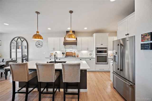 1485 Captiva Beach Ln, Monument, CO 80132 - kitchen featuring appliances with stainless steel finishes, light countertops, decorative backsplash, white cabinetry, and a breakfast bar