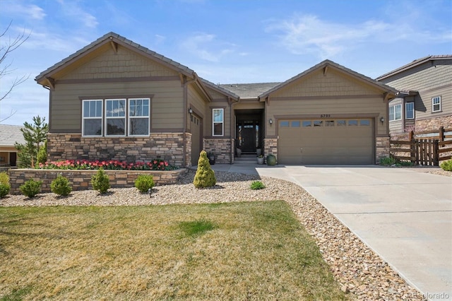 craftsman-style home featuring an attached garage, concrete driveway, and stone siding