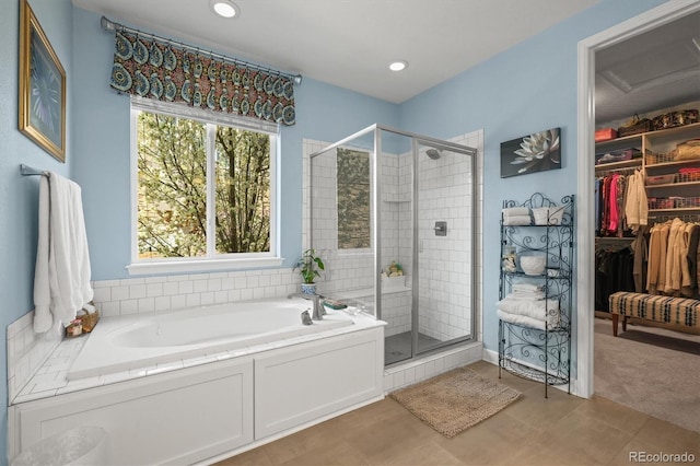 bathroom featuring a stall shower, a garden tub, a walk in closet, and recessed lighting