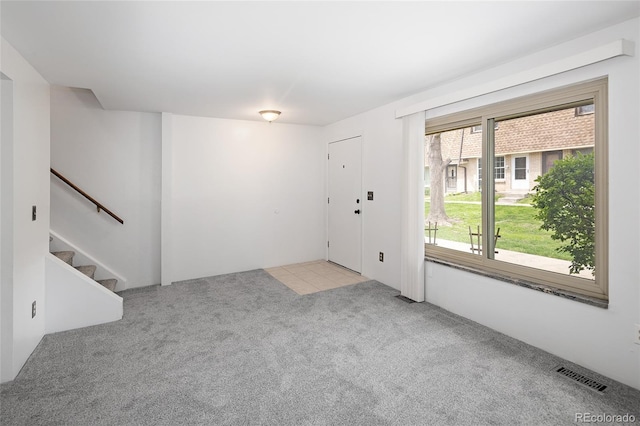 interior space featuring stairs, light carpet, and visible vents