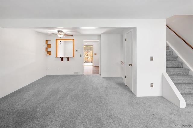 unfurnished room featuring stairway, carpet flooring, a ceiling fan, and visible vents