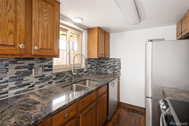 kitchen featuring visible vents, a sink, dark wood-type flooring, brown cabinets, and appliances with stainless steel finishes