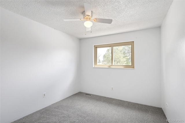 unfurnished room featuring ceiling fan, a textured ceiling, carpet flooring, and visible vents