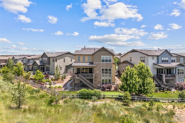 10401 Maplebrook Way, Highlands Ranch, CO 80126 - back of property featuring a residential view, stone siding, and a fenced backyard