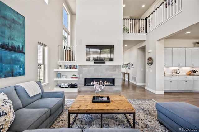 10401 Maplebrook Way, Highlands Ranch, CO 80126 - living area with a towering ceiling, wood finished floors, a fireplace, and recessed lighting