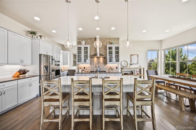 10401 Maplebrook Way, Highlands Ranch, CO 80126 - kitchen featuring tasteful backsplash, dark wood-type flooring, recessed lighting, glass insert cabinets, and a kitchen breakfast bar