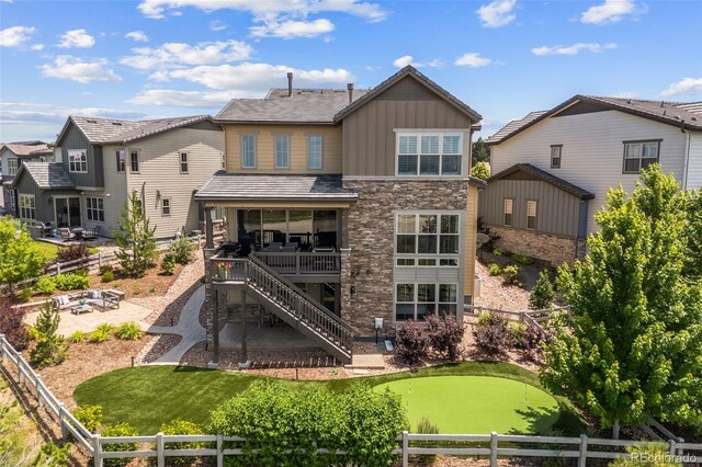 10401 Maplebrook Way, Highlands Ranch, CO 80126 - back of house featuring a putting area, board and batten siding, a fenced backyard, a patio, and an outdoor fire pit