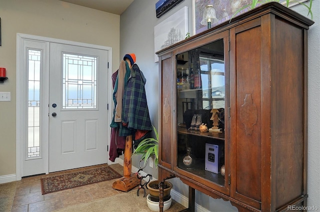 entrance foyer with stone finish floor and baseboards