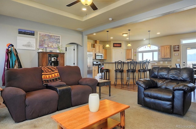living room with light carpet, recessed lighting, a ceiling fan, visible vents, and arched walkways