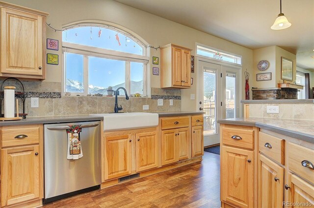 kitchen featuring visible vents, a sink, light wood-type flooring, light brown cabinetry, and stainless steel dishwasher