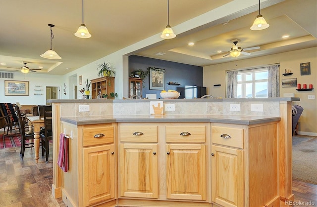 kitchen with open floor plan, a tray ceiling, and a ceiling fan