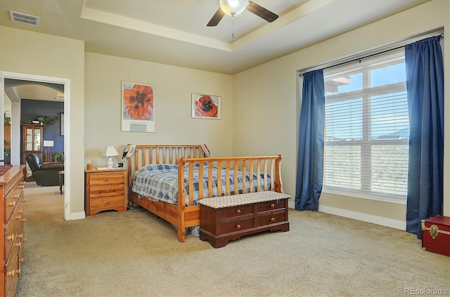 bedroom featuring light carpet, visible vents, and multiple windows