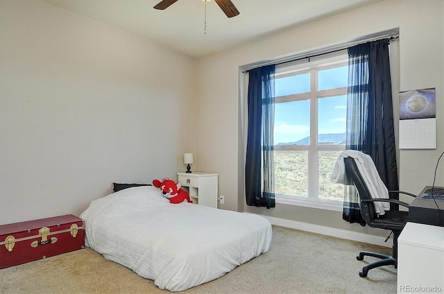 bedroom featuring multiple windows, baseboards, a ceiling fan, and carpet floors