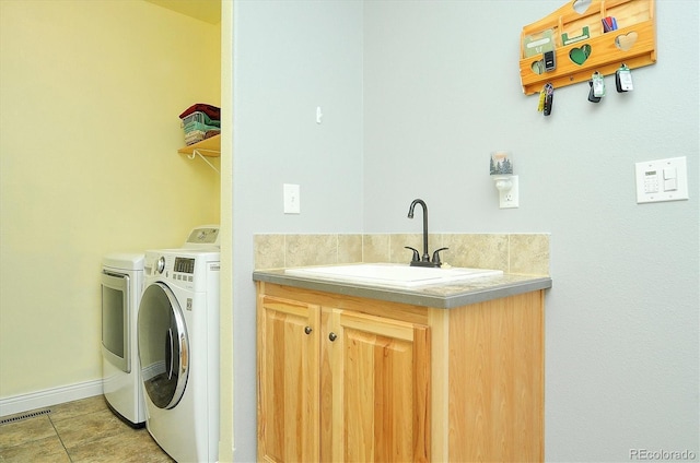 laundry area with laundry area, visible vents, washing machine and clothes dryer, a sink, and baseboards