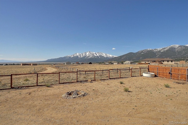 view of yard featuring fence, a mountain view, and a rural view