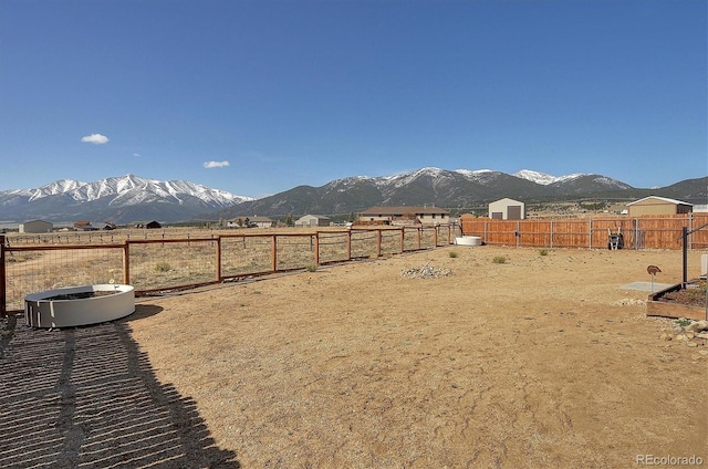 view of yard with a mountain view and fence