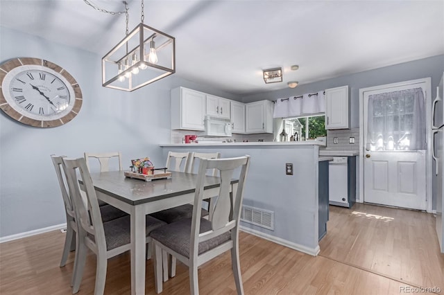 4676 S Dillon Ct Unit G, Aurora, CO 80015 - dining area featuring light wood-style flooring and a chandelier