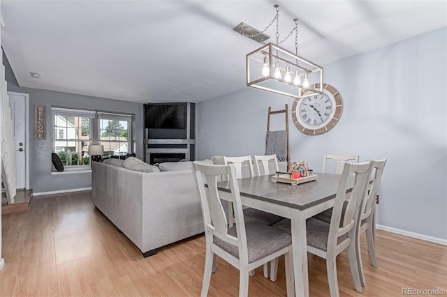 4676 S Dillon Ct Unit G, Aurora, CO 80015 - dining area featuring light wood finished floors, a fireplace, and a chandelier