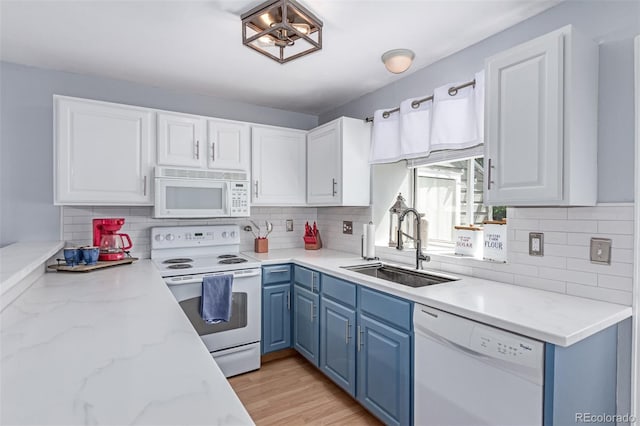 4676 S Dillon Ct Unit G, Aurora, CO 80015 - kitchen featuring white appliances, blue cabinets, decorative backsplash, and white cabinets