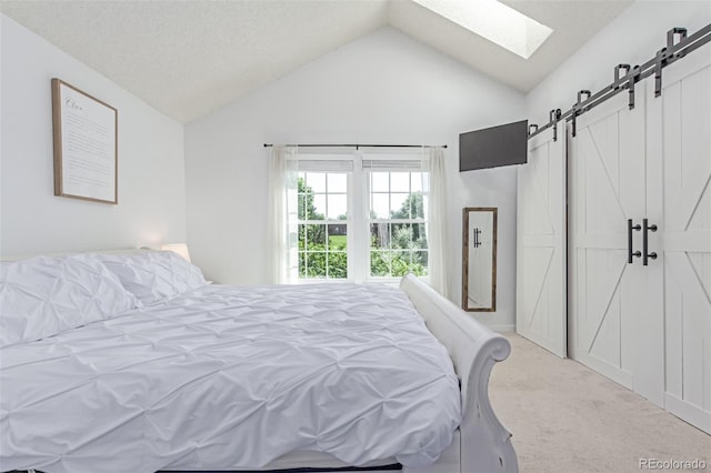 4676 S Dillon Ct Unit G, Aurora, CO 80015 - bedroom featuring a barn door, carpet flooring, vaulted ceiling, and a skylight