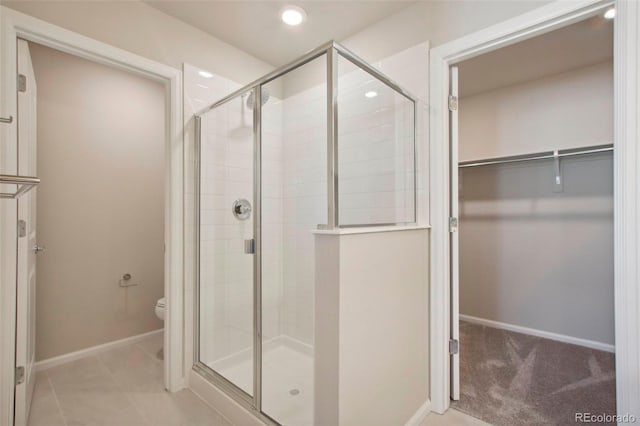 bathroom with a shower with door and toilet