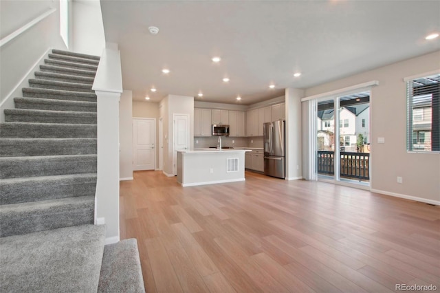 unfurnished living room featuring light hardwood / wood-style floors and sink