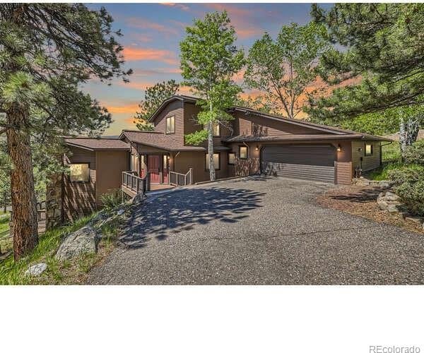 mid-century home featuring a garage and driveway