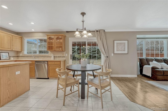 dining room featuring an inviting chandelier, sink, and light tile patterned flooring