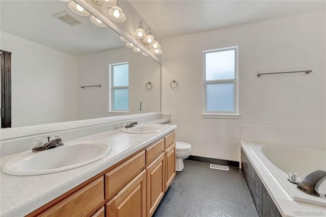 bathroom featuring vanity, toilet, and tiled bath