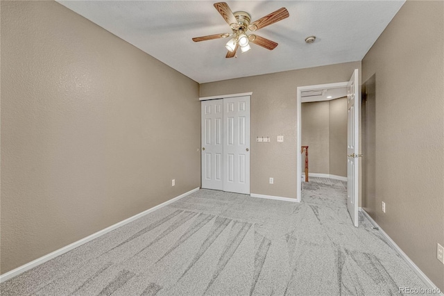 unfurnished bedroom with light carpet, ceiling fan, and a closet