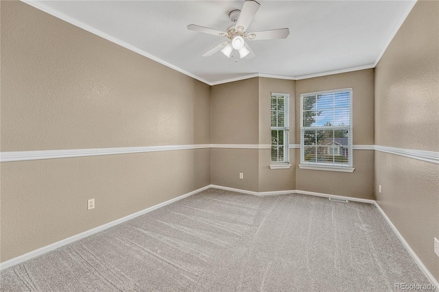 carpeted empty room with crown molding and ceiling fan