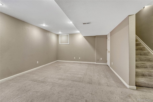 basement with carpet floors and a textured ceiling