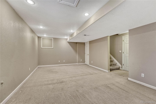 basement with light colored carpet and a textured ceiling