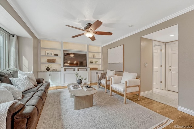 living room with ornamental molding, ceiling fan, built in features, and light hardwood / wood-style floors