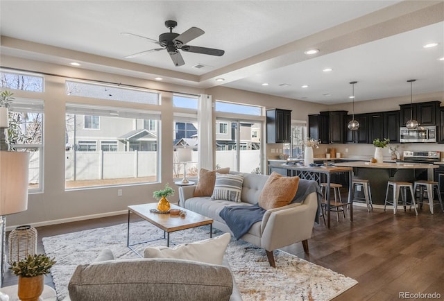 living room with ceiling fan and dark wood-type flooring